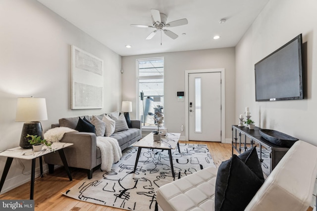 living room with light wood-type flooring and ceiling fan