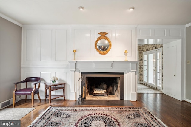 sitting room featuring dark hardwood / wood-style flooring, ornamental molding, and french doors