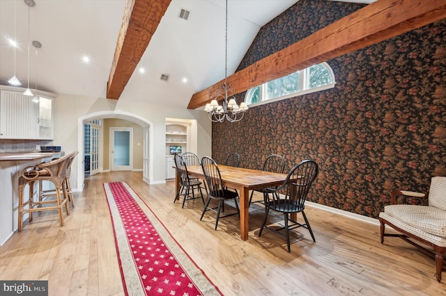 dining room with a chandelier, vaulted ceiling with beams, and light hardwood / wood-style floors