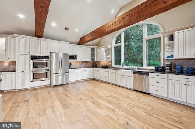 kitchen with beam ceiling, white cabinetry, tasteful backsplash, light hardwood / wood-style floors, and appliances with stainless steel finishes