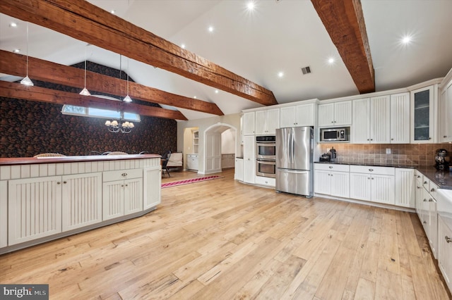 kitchen featuring pendant lighting, white cabinetry, stainless steel appliances, and beamed ceiling