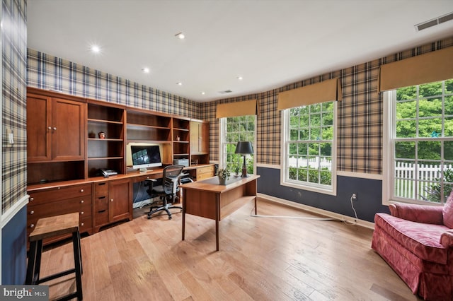 home office with light hardwood / wood-style flooring