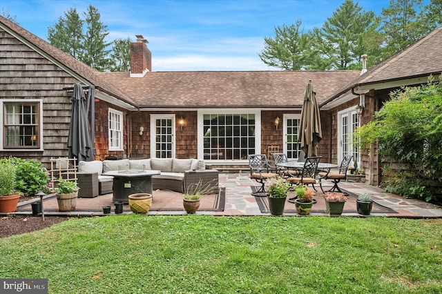 back of property with a yard, an outdoor living space, and a patio area