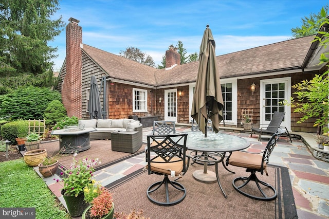 view of patio with an outdoor living space with a fire pit