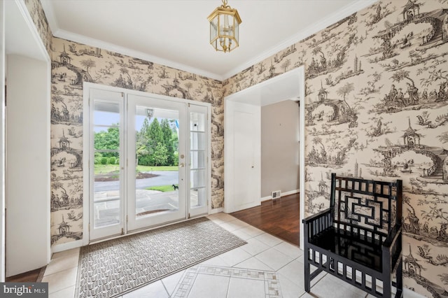 doorway to outside with a notable chandelier, light tile patterned floors, and crown molding