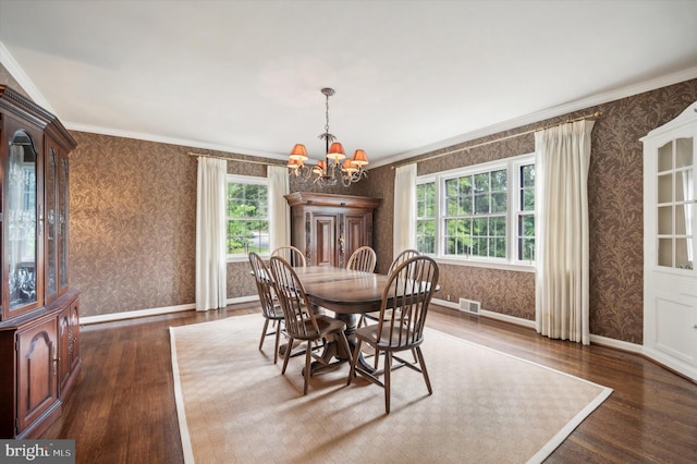 dining area featuring dark hardwood / wood-style floors, an inviting chandelier, and ornamental molding