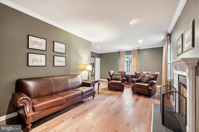 living room featuring light hardwood / wood-style floors, ornamental molding, and a high end fireplace