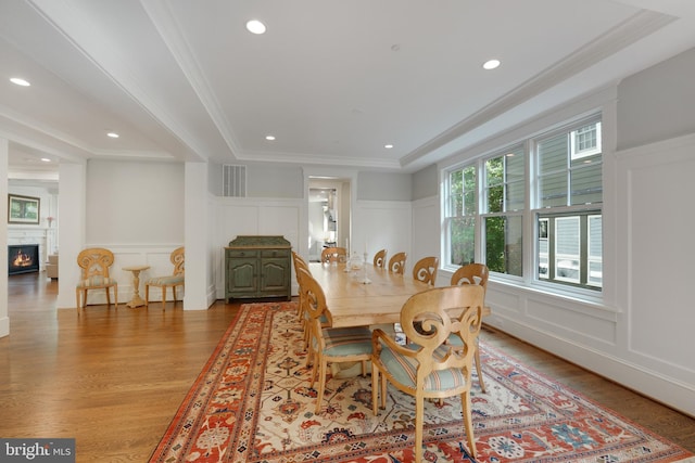 dining area featuring ornamental molding, light hardwood / wood-style floors, and a tray ceiling