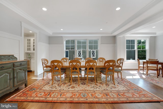 dining space with wine cooler, wood-type flooring, and ornamental molding