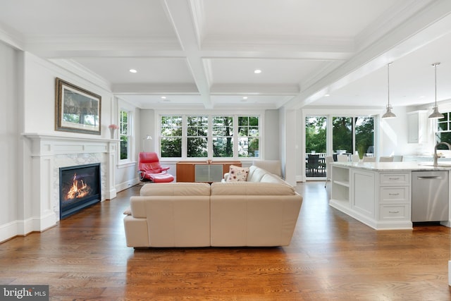 living room with beam ceiling, sink, coffered ceiling, dark hardwood / wood-style flooring, and a high end fireplace