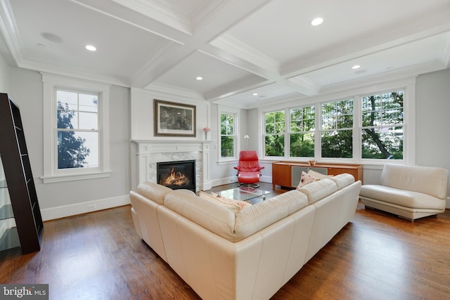 living room with beamed ceiling, a high end fireplace, a wealth of natural light, and coffered ceiling