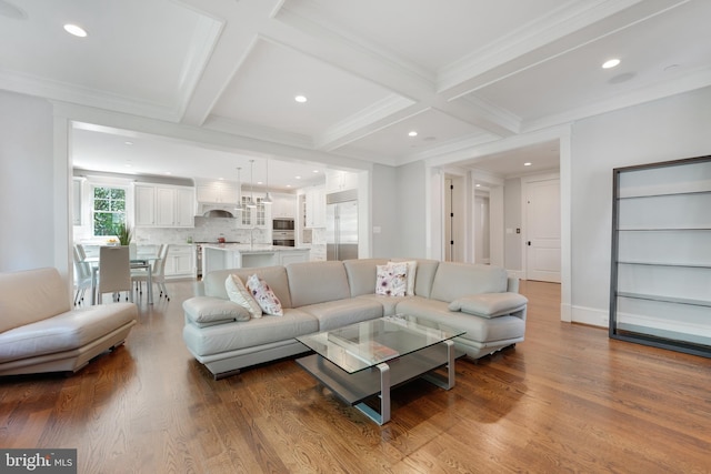 living room featuring beamed ceiling, wood-type flooring, and ornamental molding