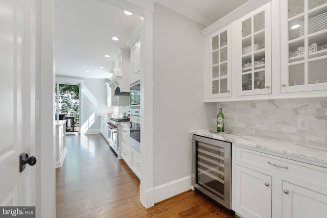 bar with appliances with stainless steel finishes, wine cooler, tasteful backsplash, dark hardwood / wood-style floors, and white cabinetry