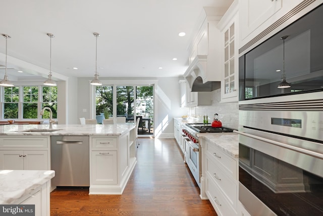 kitchen featuring backsplash, white cabinetry, sink, and appliances with stainless steel finishes