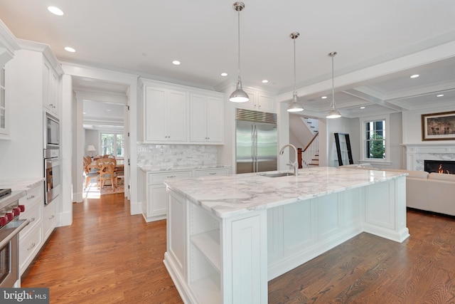 kitchen with beam ceiling, built in appliances, and white cabinets