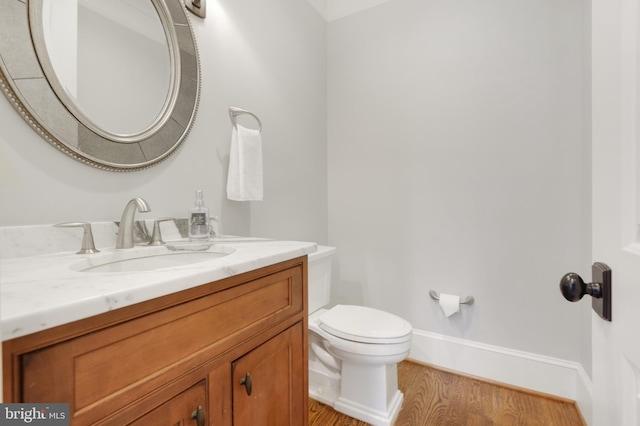 bathroom with vanity, wood-type flooring, and toilet