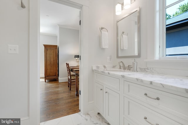 bathroom with a wealth of natural light, vanity, and ornamental molding