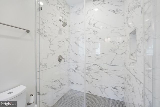 bathroom with tiled shower and toilet