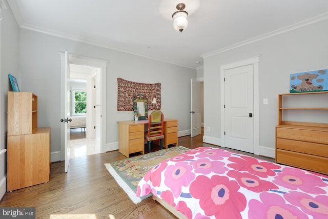 bedroom with crown molding and hardwood / wood-style flooring