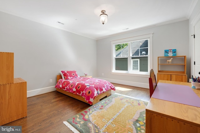 bedroom with dark hardwood / wood-style floors and ornamental molding