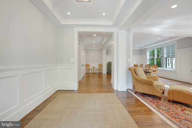 hallway featuring crown molding and light hardwood / wood-style flooring