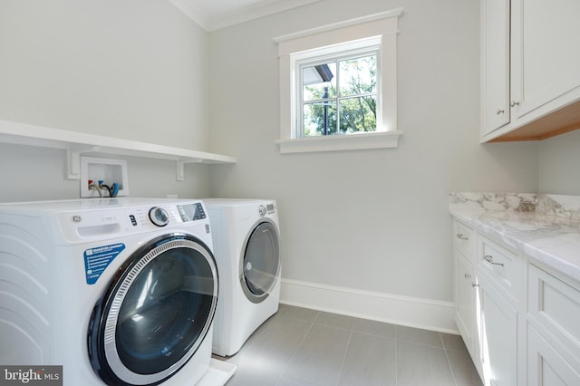 clothes washing area with washer and dryer, light tile patterned floors, and cabinets