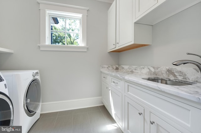 laundry room featuring cabinets, sink, dark tile patterned flooring, and washing machine and clothes dryer