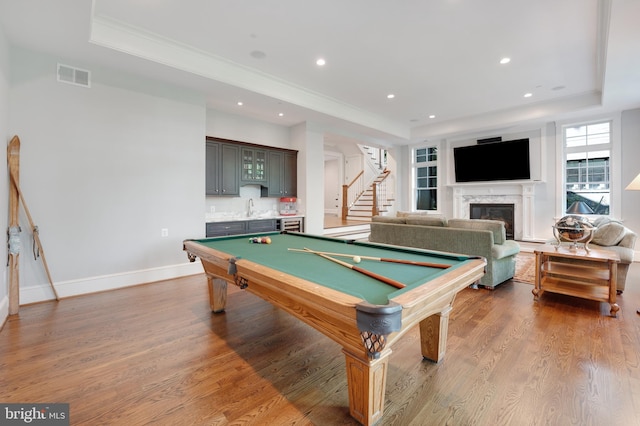 rec room featuring pool table, wet bar, a high end fireplace, and a tray ceiling