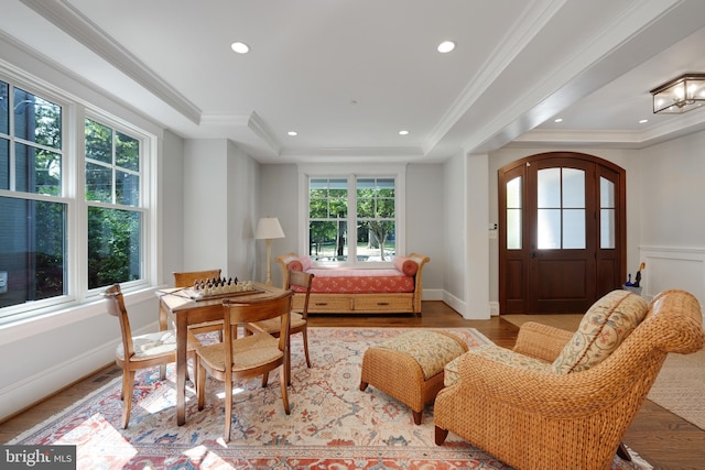 interior space featuring crown molding, a tray ceiling, and light hardwood / wood-style flooring