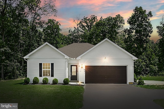 ranch-style home with a yard and a garage