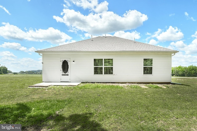 rear view of property with a lawn and a patio