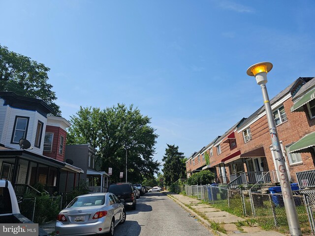 view of street with curbs, street lighting, sidewalks, and a residential view