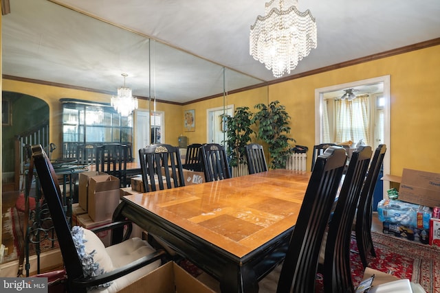 dining space featuring ornamental molding and a notable chandelier