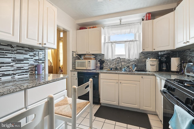 kitchen with sink, white cabinets, black appliances, and light tile patterned floors