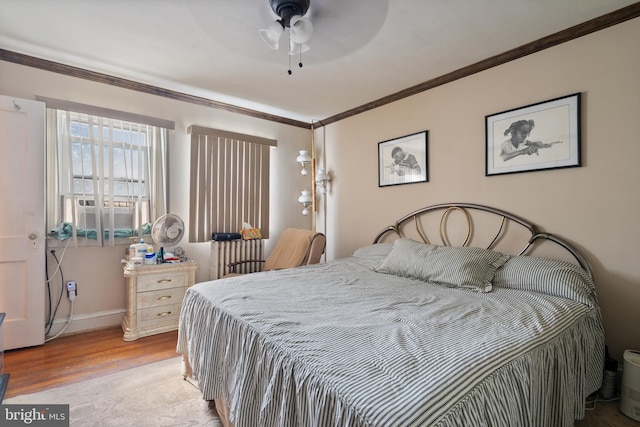 bedroom with light hardwood / wood-style floors, ceiling fan, and crown molding