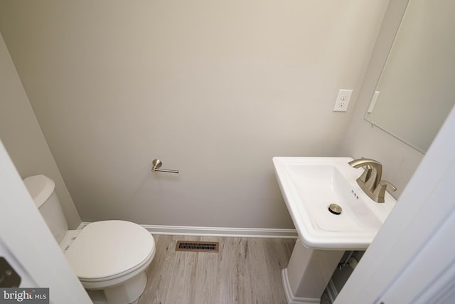 bathroom featuring sink, toilet, and hardwood / wood-style flooring