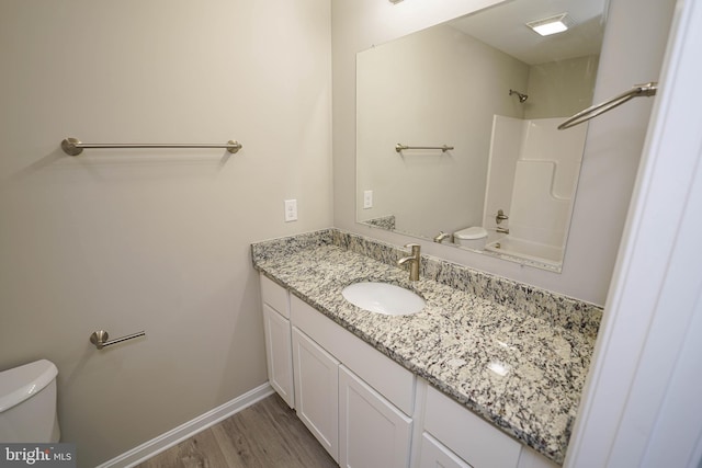 full bathroom featuring hardwood / wood-style flooring, vanity, toilet, and shower / washtub combination