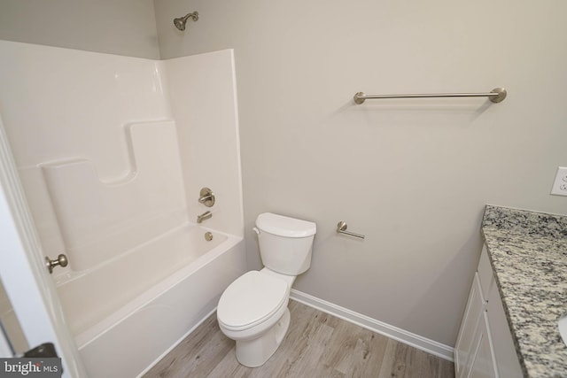 full bathroom with vanity, hardwood / wood-style floors, washtub / shower combination, and toilet