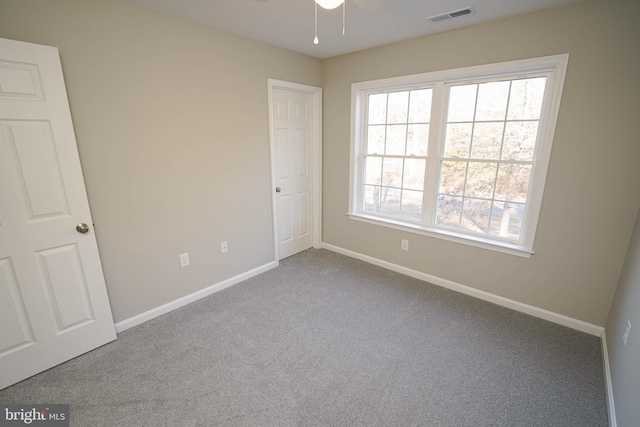 carpeted empty room featuring ceiling fan