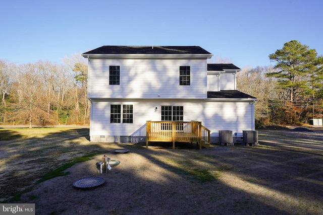 rear view of property with a yard, a deck, and central air condition unit