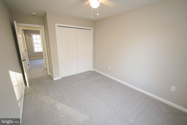 unfurnished bedroom featuring light colored carpet, a closet, and ceiling fan