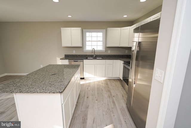 kitchen with a kitchen island, sink, white cabinetry, and stainless steel appliances