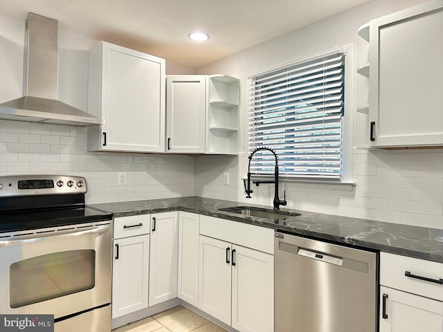 kitchen featuring stainless steel appliances, white cabinetry, sink, and wall chimney range hood