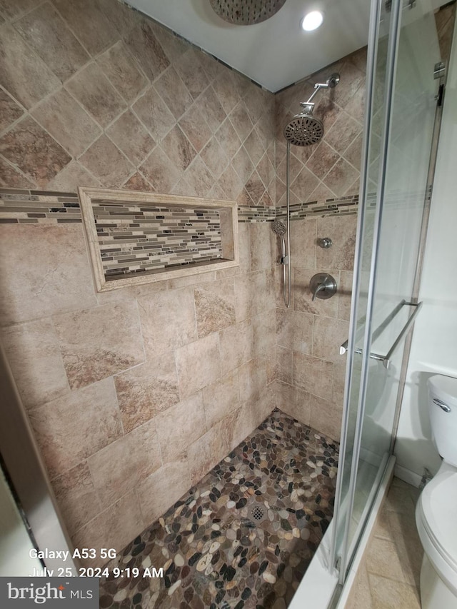 bathroom with tiled shower and toilet