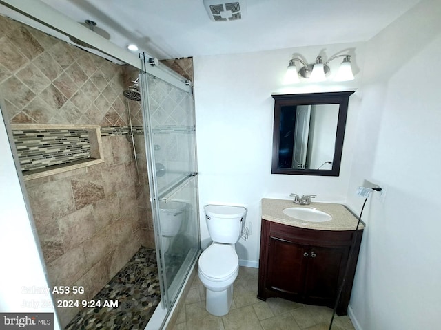 bathroom with vanity, a shower with shower door, and toilet