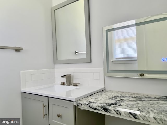 bathroom featuring vanity and tasteful backsplash