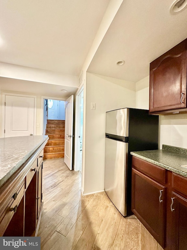 kitchen with stainless steel fridge and light hardwood / wood-style floors