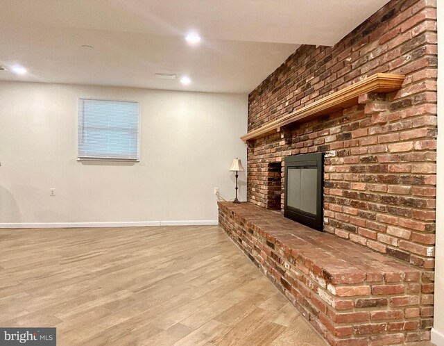 unfurnished living room featuring a fireplace and light hardwood / wood-style floors