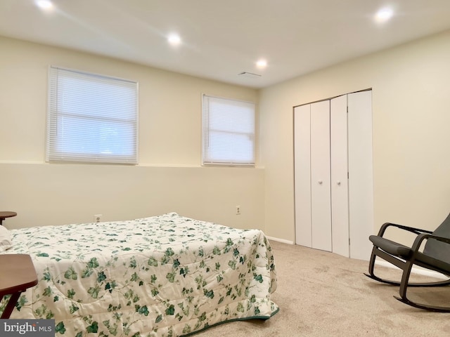 bedroom with light colored carpet and a closet