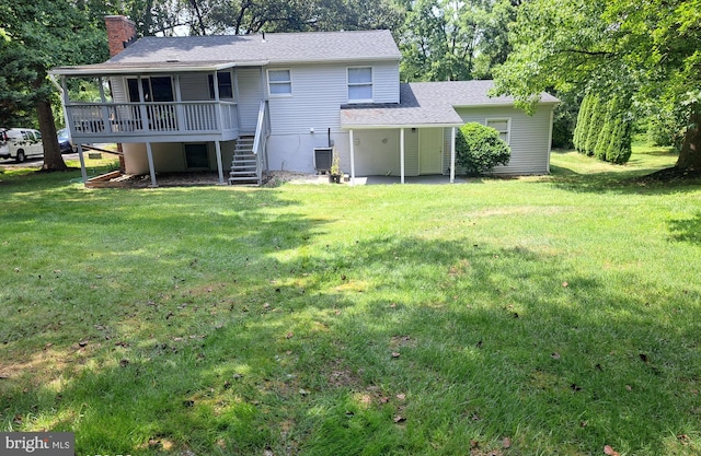 rear view of property with a wooden deck, a yard, and central AC unit